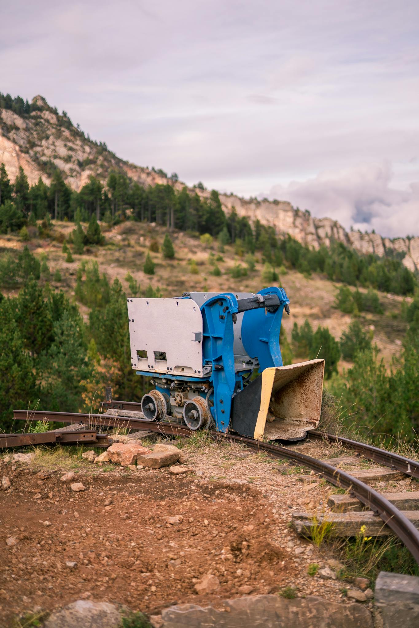 Mining machinery on a curved track in Vallcebre with mountainous backdrop.